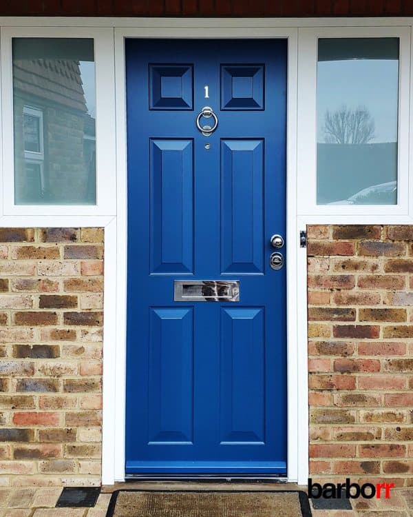 Porte d’entrée blindée bleue sur une maison en brique