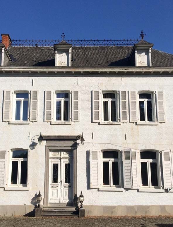 Manoir blanc rénové avec fenêtres bois et volets