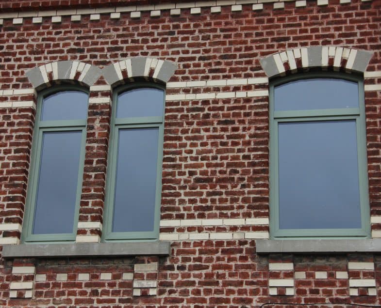 Façade en brique rénovée avec fenêtres bois cintrées