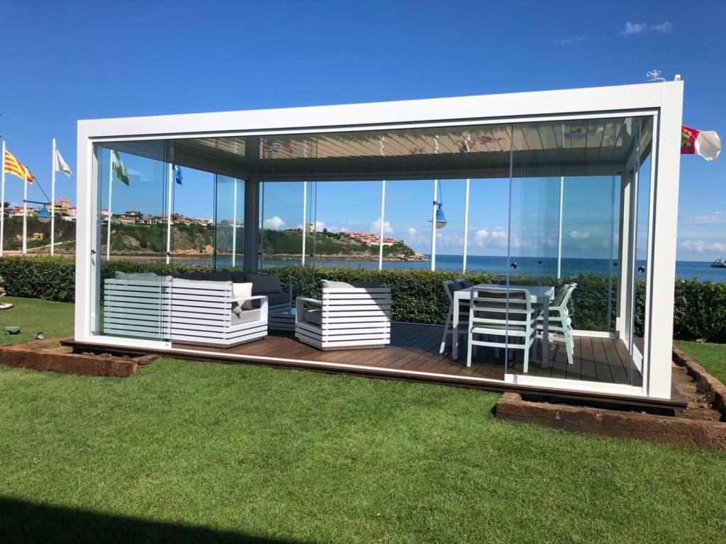 Pergola en îlot avec parois vitrées au milieu d’un jardin