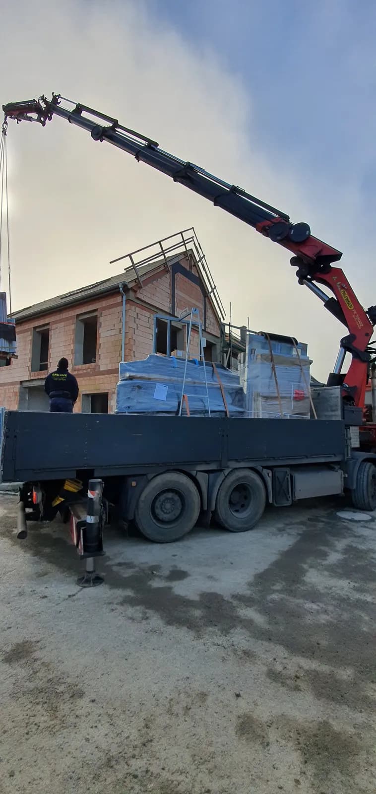 Palettes de fenêtres déchargées devant une maison en construction