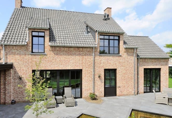 Maison en brique avec fines fenêtres aluminium noires de style acier