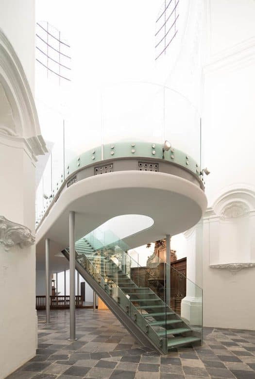 Mezzanine arrondie bordée d’un garde-corps en verre