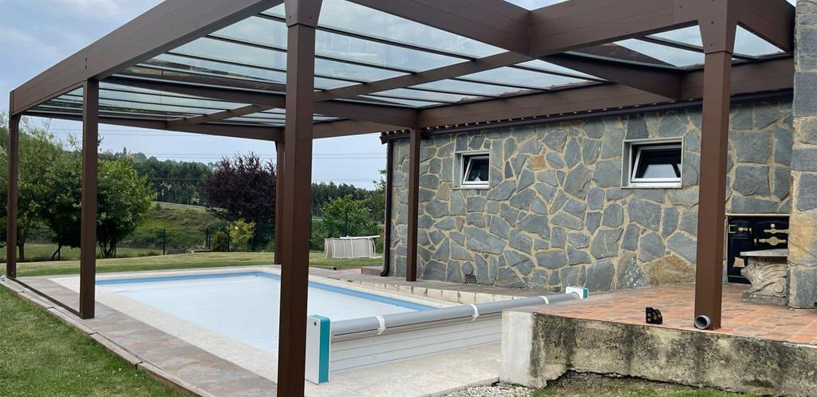 Pergola fermée de verre au bord d’une piscine