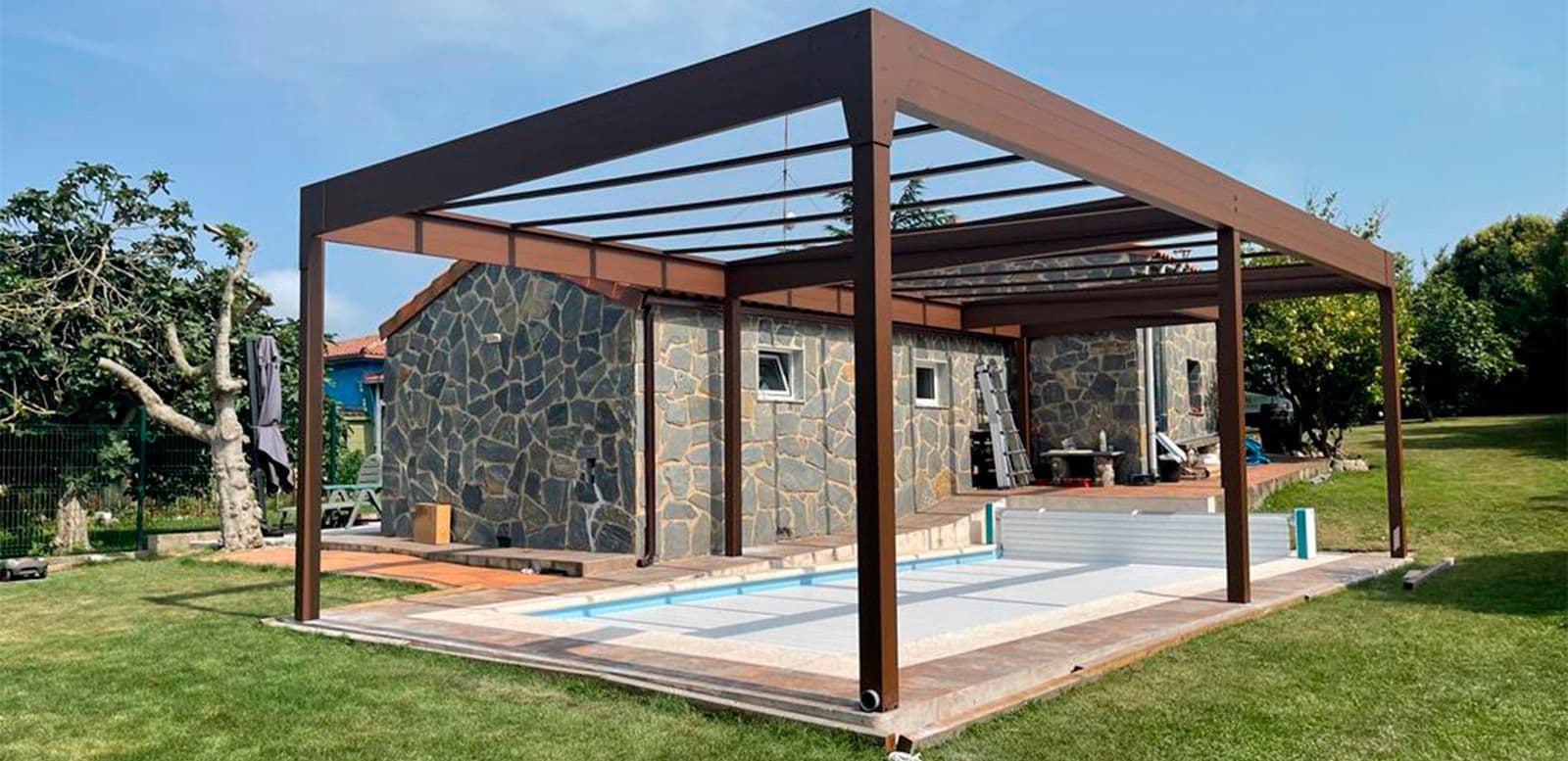 Pergola fermée de verre au bord d’une piscine