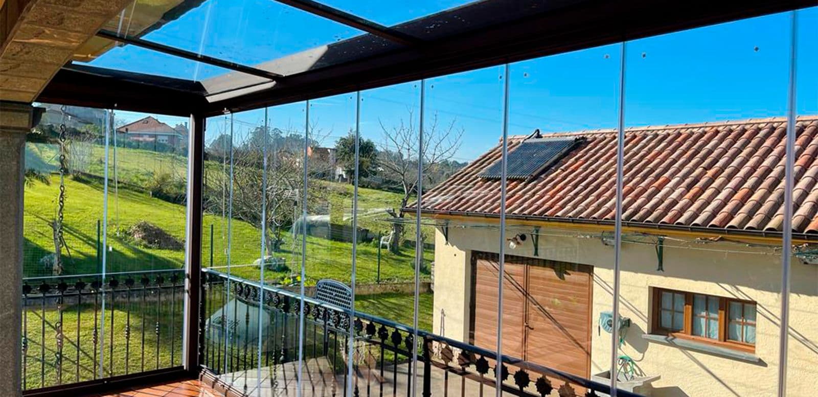 Terrasse couverte par une pergola avec parois vitrées coulissantes