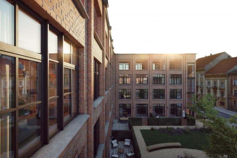 Immeuble en brique de style industriel avec fenêtres PVC sombres