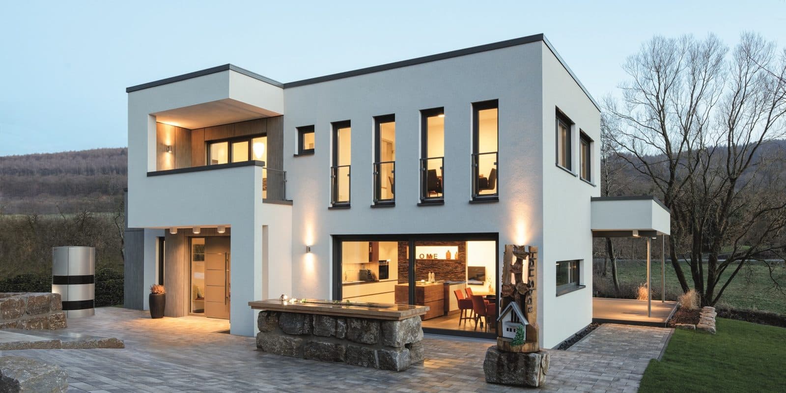 Maison contemporaine équipée de fenêtres PVC, éclairée le soir