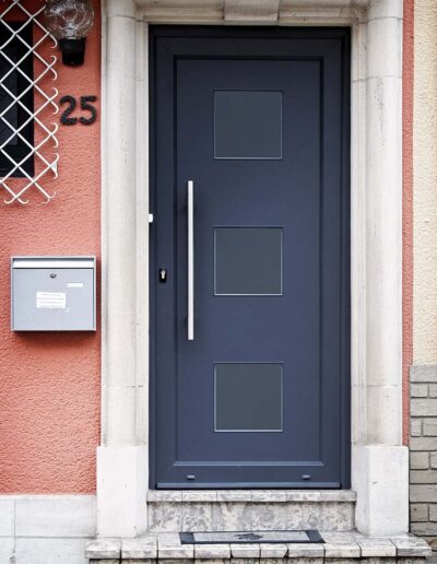 Graue Haustür mit runden Glasausschnitten, eingebaut von Winfox