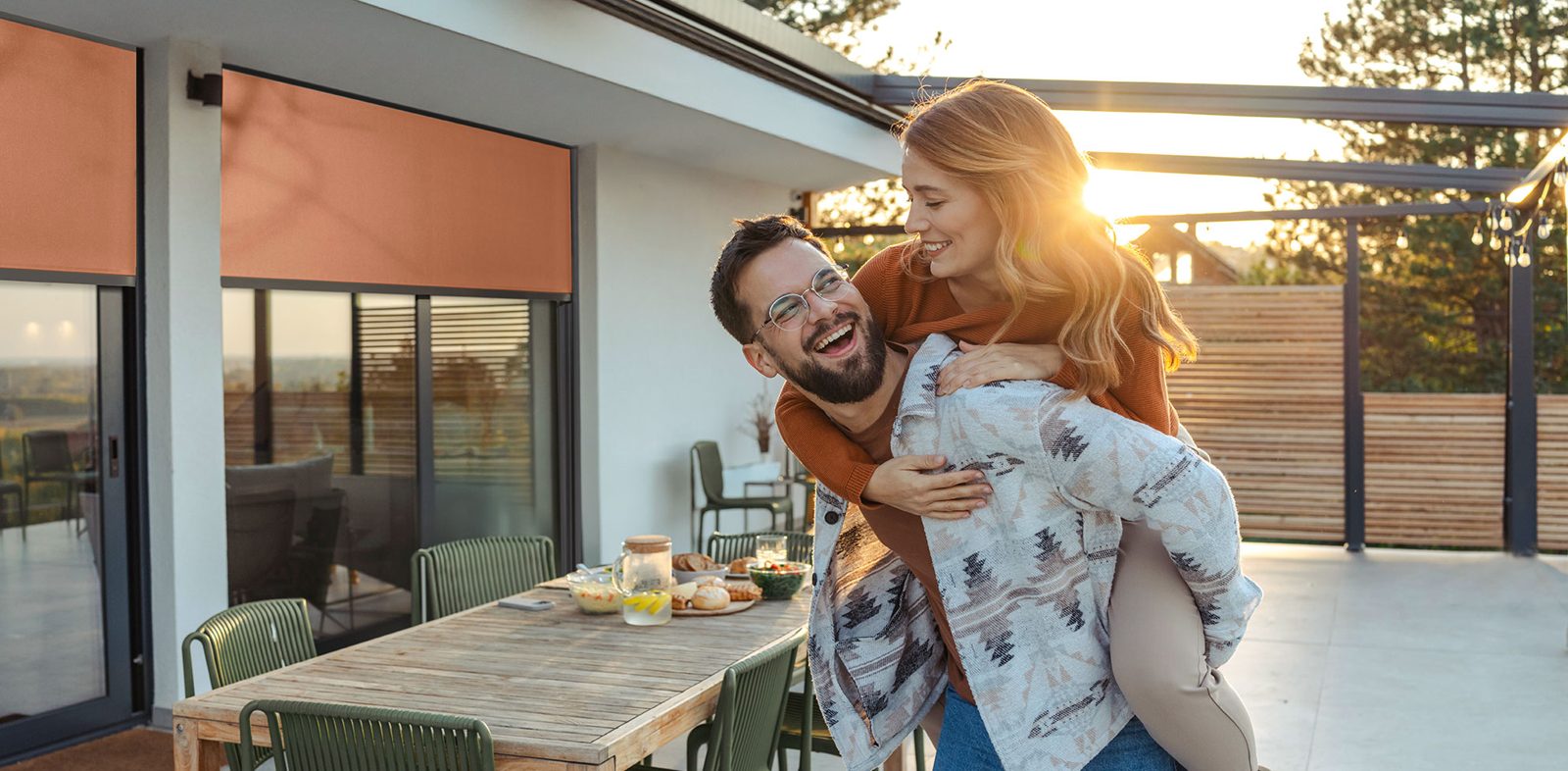 Paar auf der Terrasse vor Fenstern mit Lakal-Rollläden
