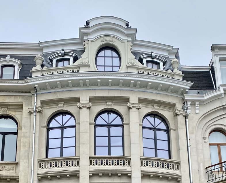 Façade de maison de maître avec fenêtres bois cintrées refaites à l’identique