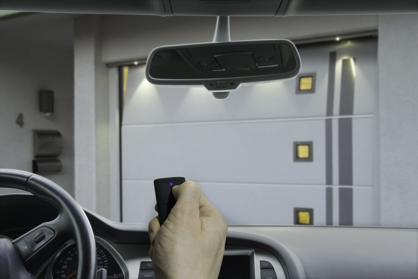 Conducteur ouvrant sa porte de garage avec la télécommande depuis la voiture